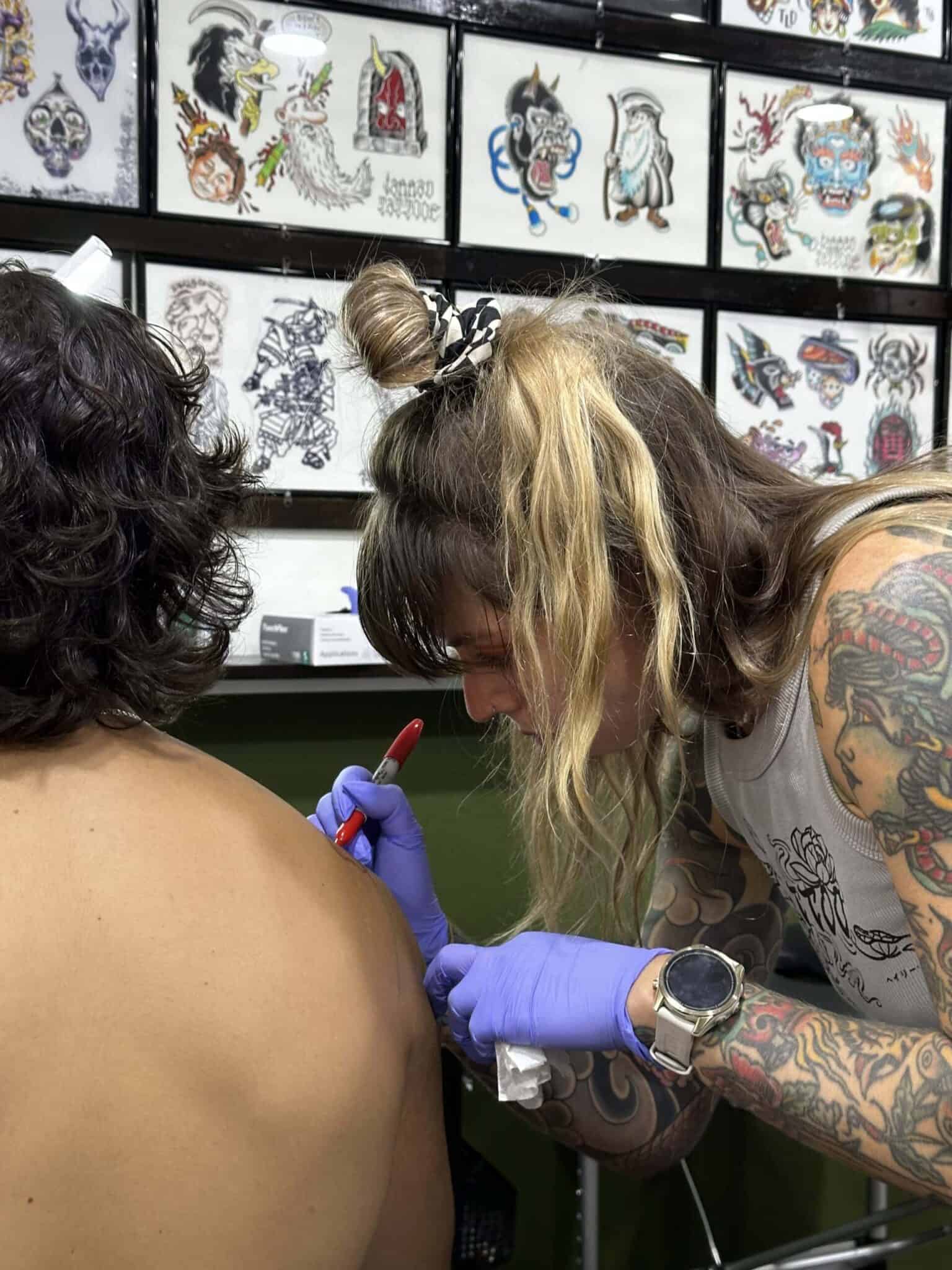 Maddi tattooing a client